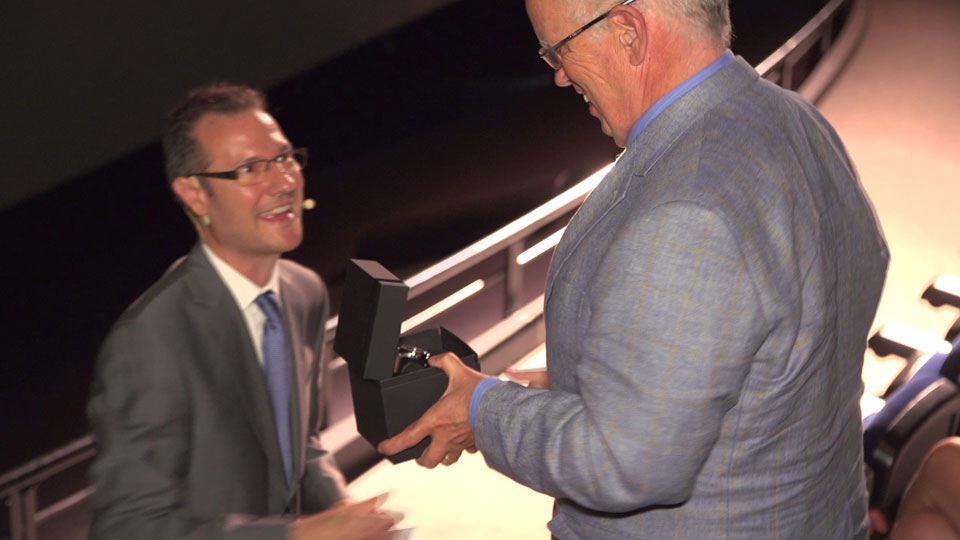 Kurator Philipp Portmann übergibt Ehrengast Eugene Chaplin eine Uhr